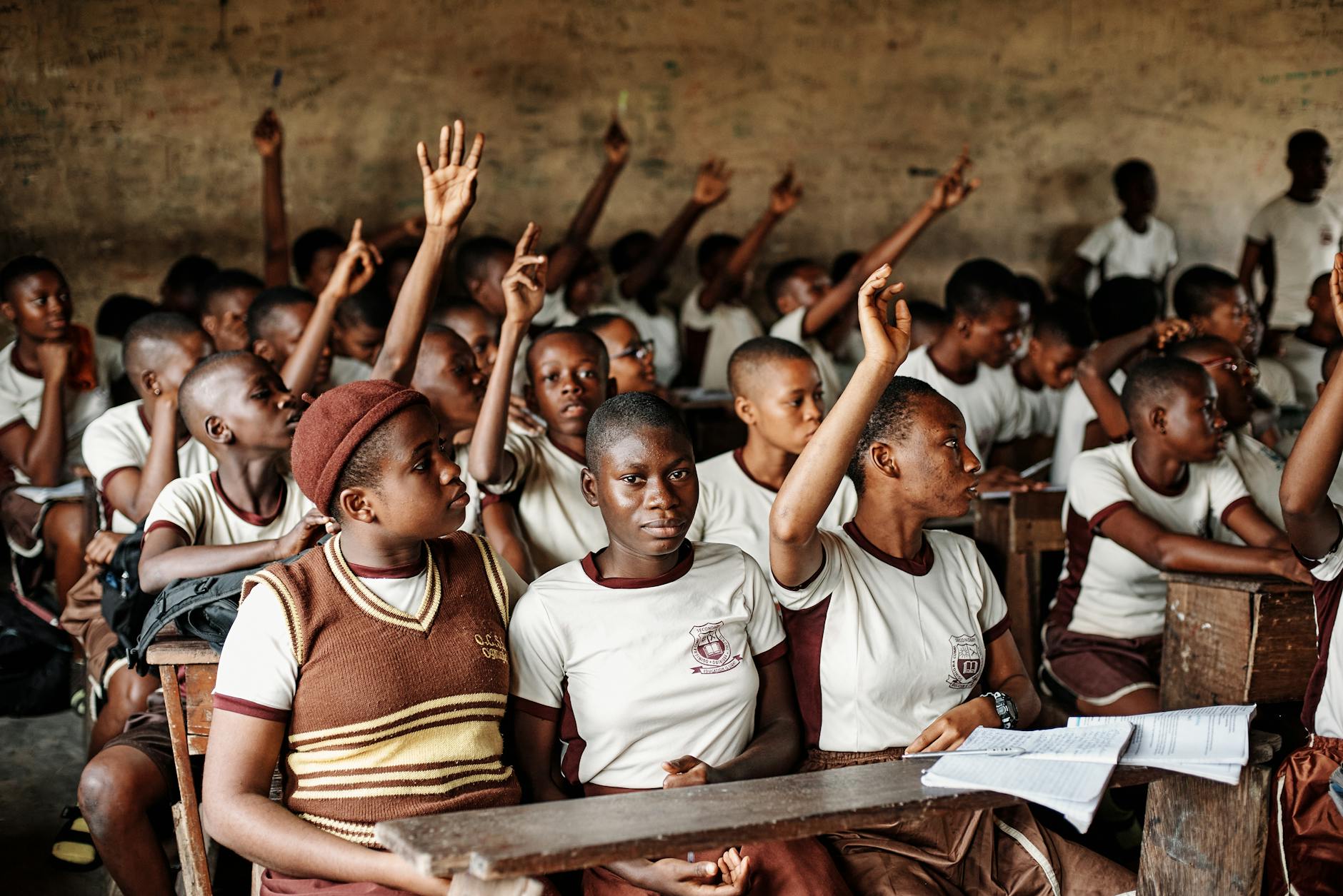 students with hands raised